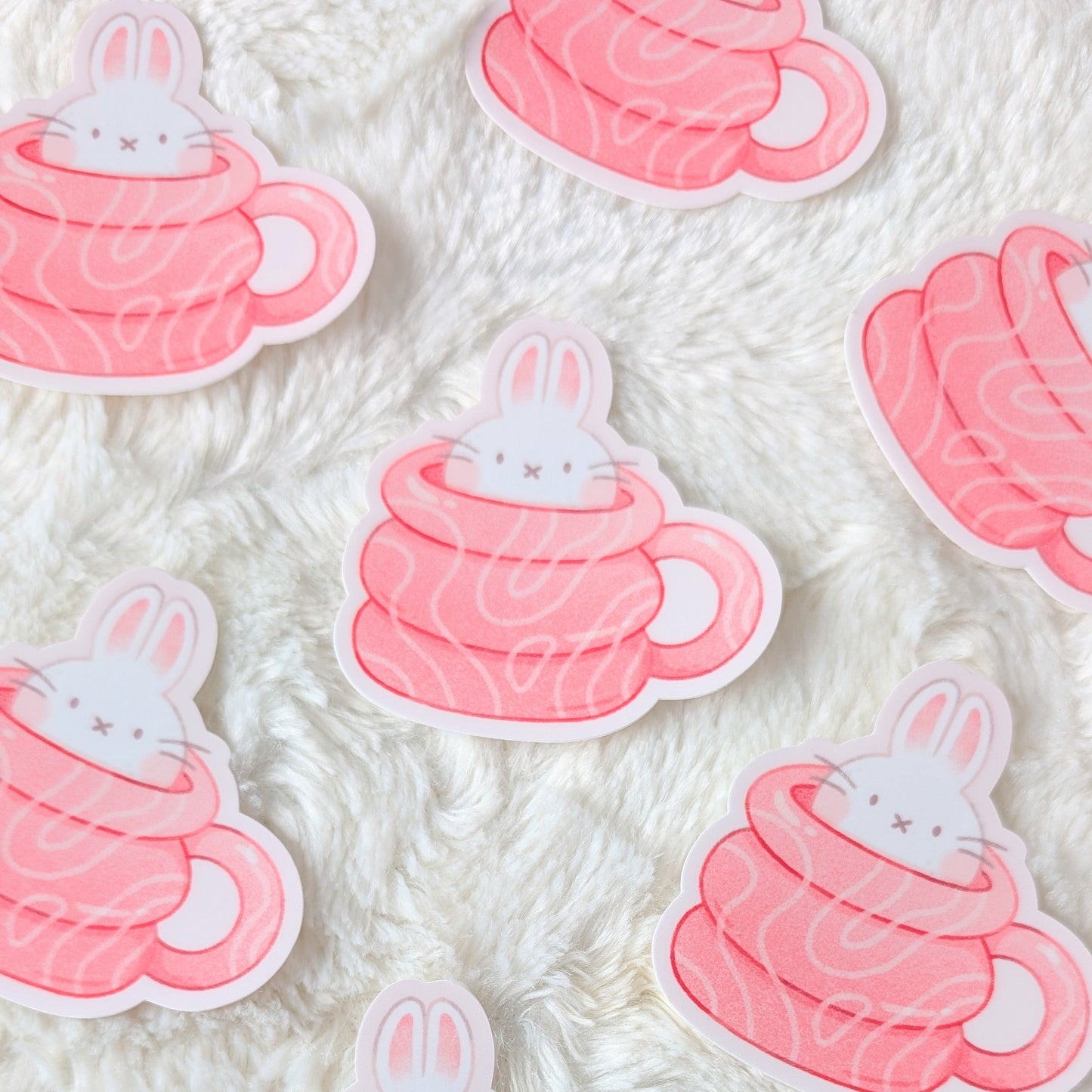 Stickers of bunnies in hot chocolate cups on a textured white background