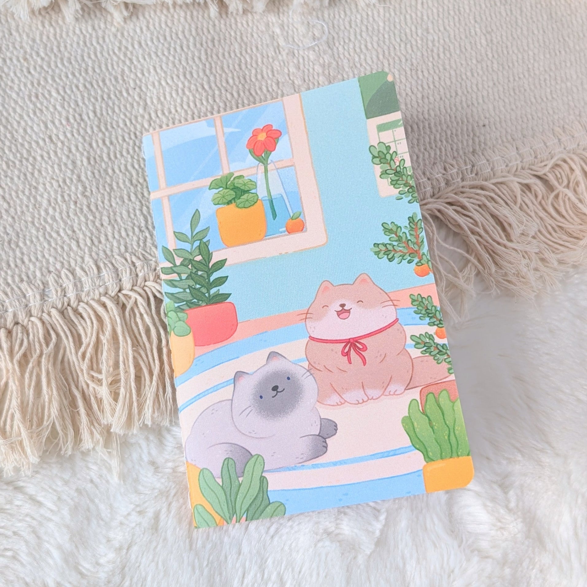 Notebook with cartoon cat design on a textured surface