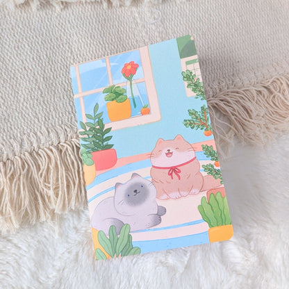 Notebook with cartoon cat design on a textured surface