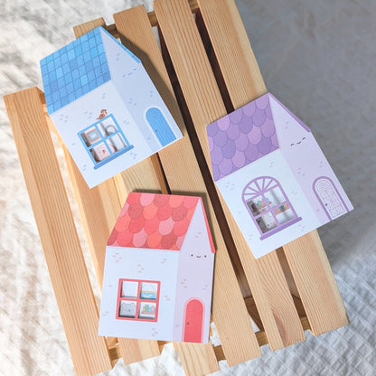 Colorful house-shaped cards on a wooden stand with a soft white background