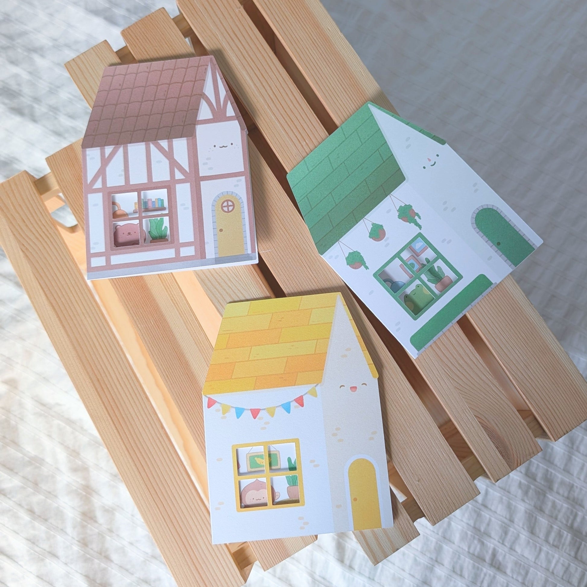 Colorful house-shaped cards on a wooden stand with a white background